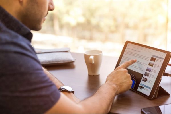 A guy browsing the net using an iPad.