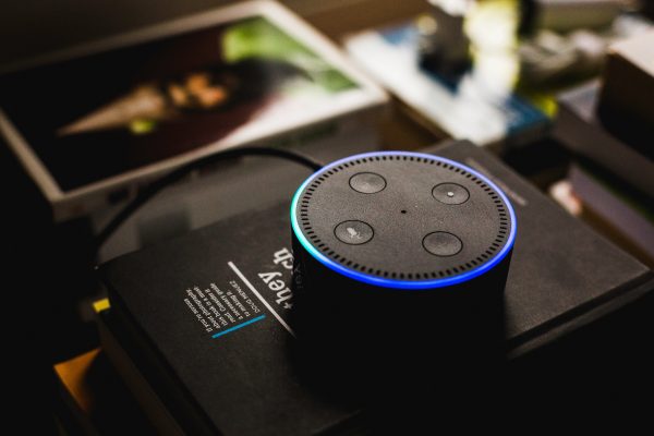 Black portable speaker with four buttons on top.