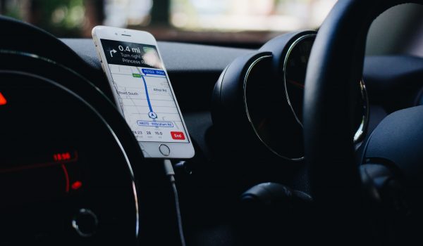 A white iPhone fastened in a car phone holder.