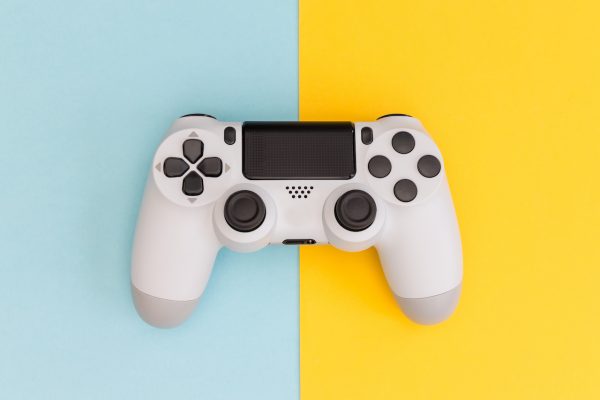 Video games white gaming controller isolated on yellow blue color background top view