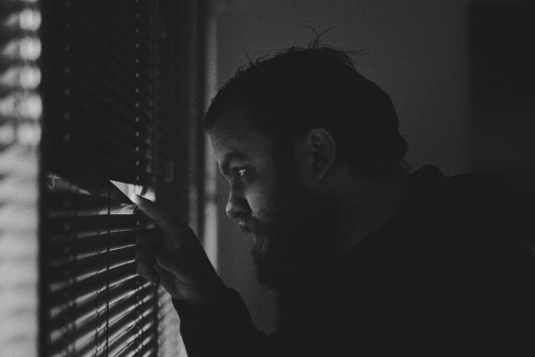 Man peering out a window