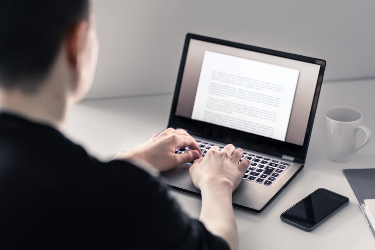 Man writing essay on laptop