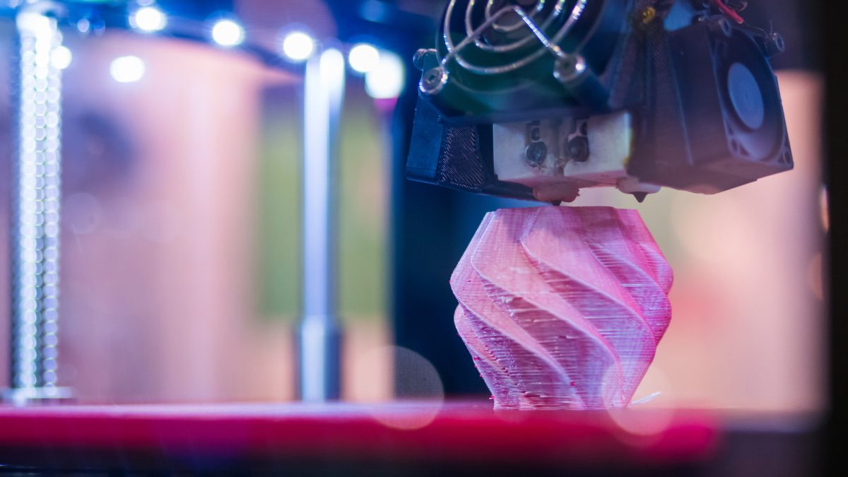 3D printer machine printing plastic model at modern scifi technology exhibition