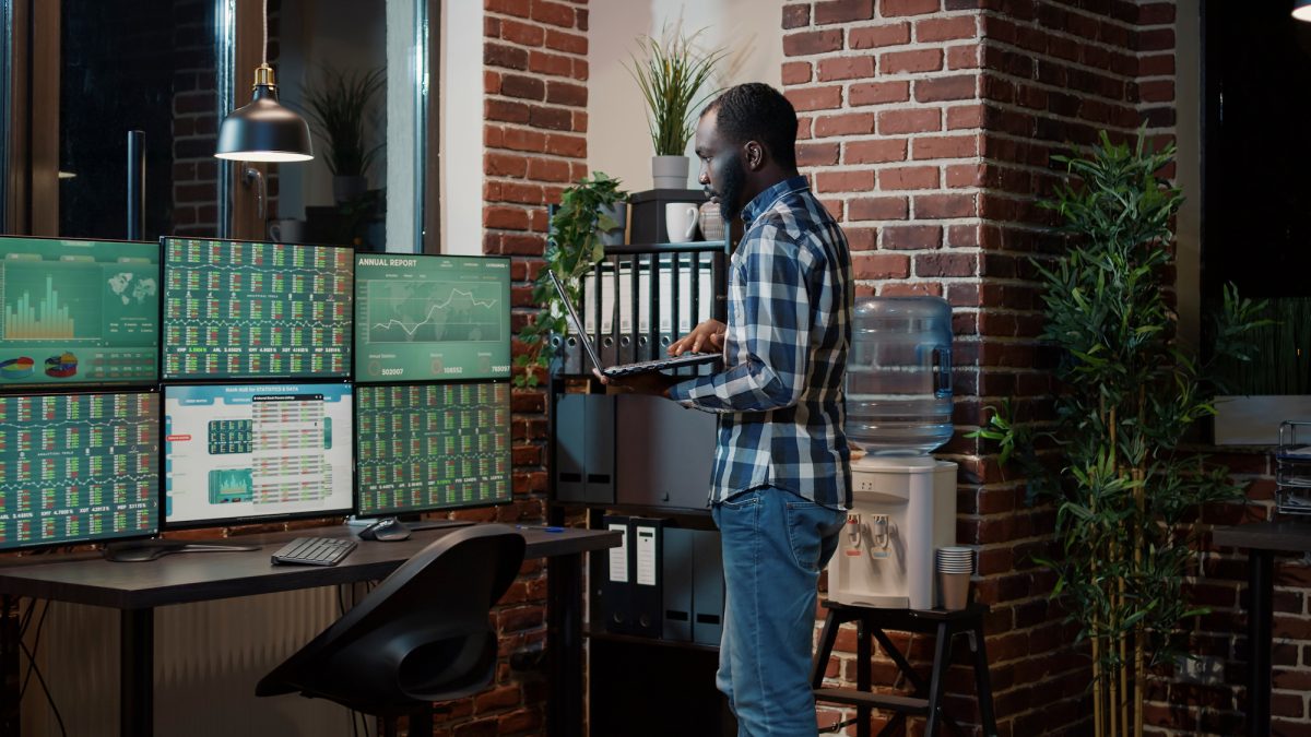 Hedge fund trader looking at real time stocks numbers on laptop